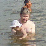 Папа опускает в воду.